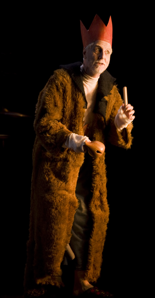 Peter Carroll as Fool, playing a small wooden instrument