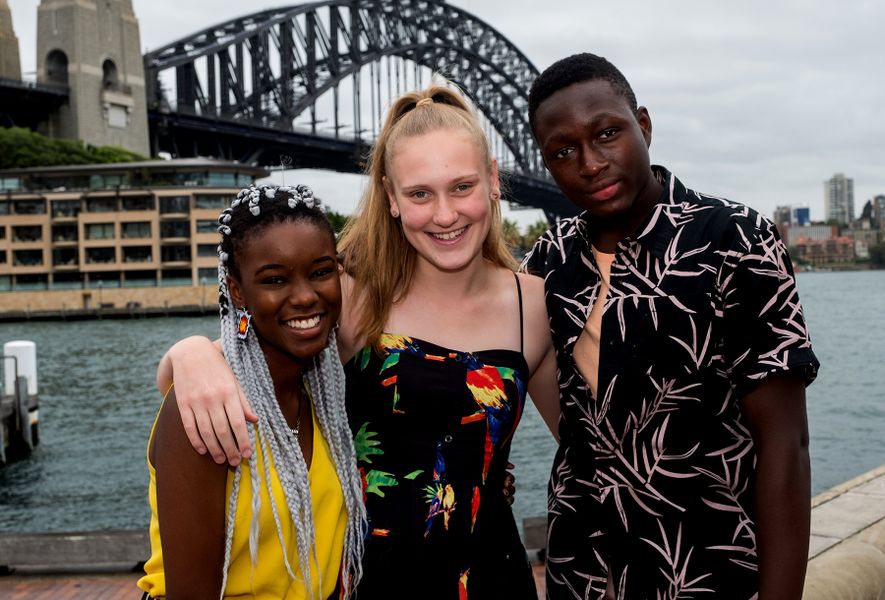 3 teenagers pose in front of Sydney Harbour Bridge