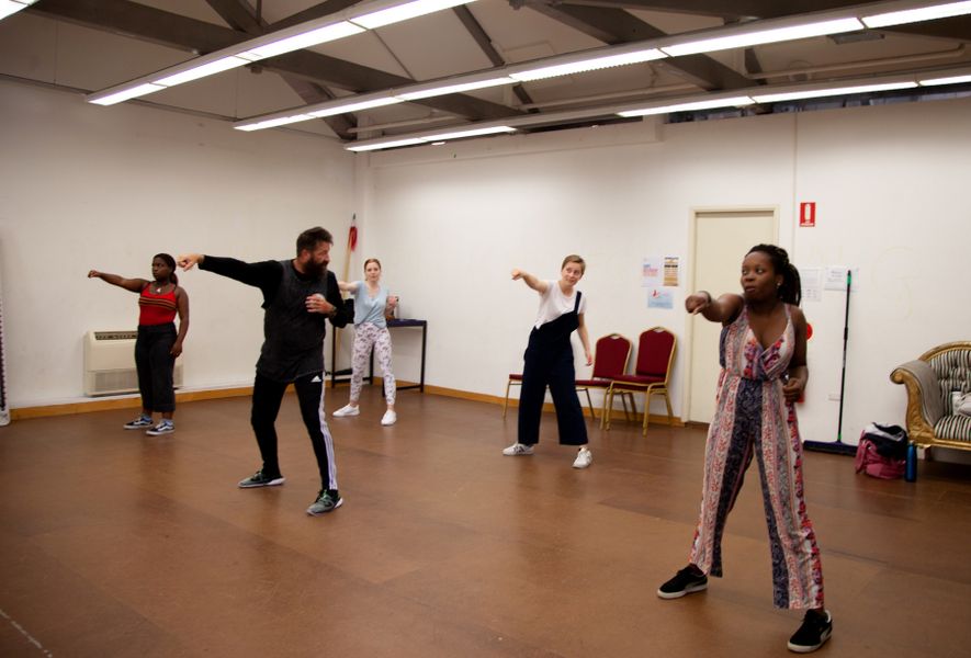 Five people in a movement workshop punching the air