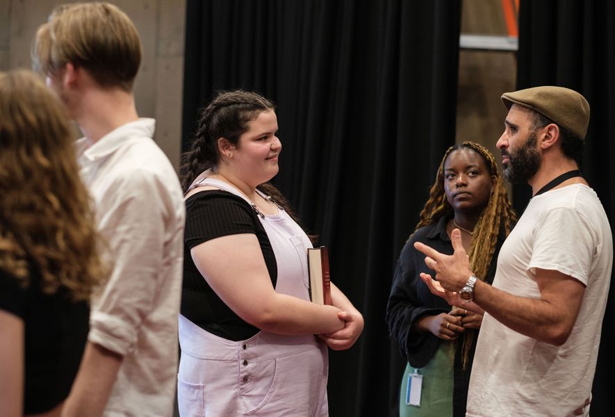 Young woman facing another man and woman talking